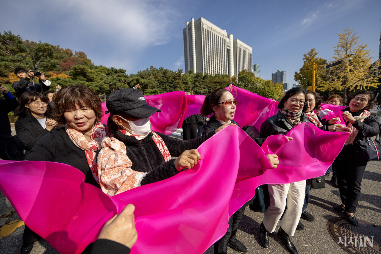 재판을 마치고 나온 피해자들이 분홍색 천을 흔들며 아리랑을 부르고 있다. ⓒ시사IN 조남진