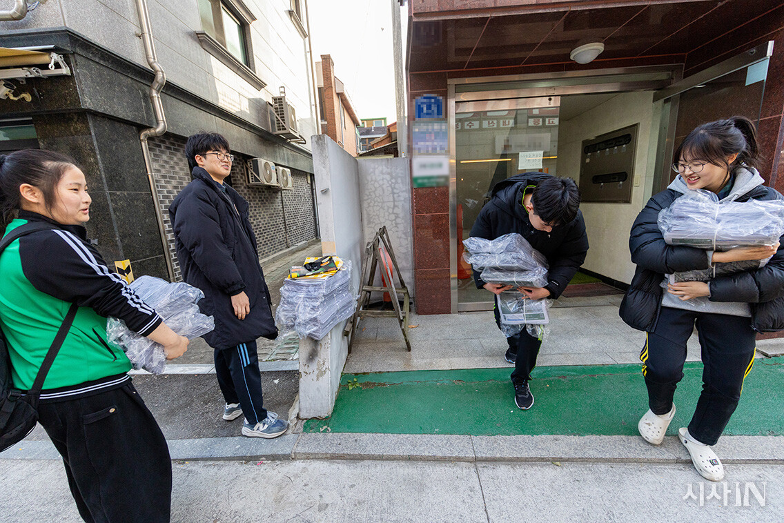 11월19일 방과후에 인쇄된 신문을 옮기고 있는  기자들 . 그동안 1000부를 인쇄하던  발행부수는 늘어난 후원자로 인해 18호부터 2000부로 증가했다. ⓒ시사IN 신선영