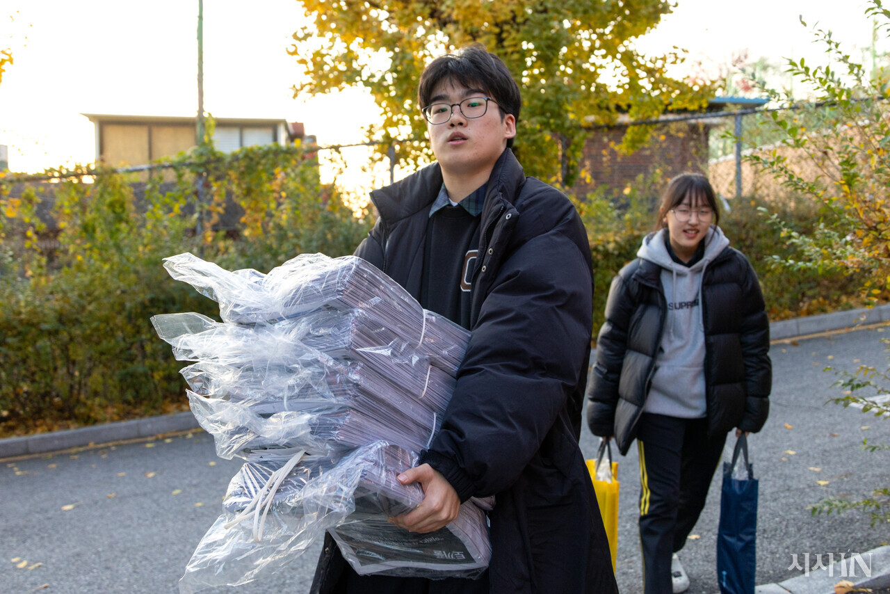 문성호 편집장과 김서연 문화부장이 여러 학교에 을 배포하기 위해 신문 더미를 옮기고 있다. ⓒ시사IN 신선영